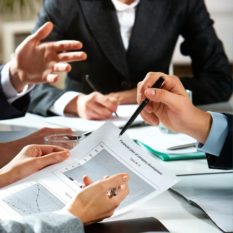 a business meeting with a man pointing to a document
